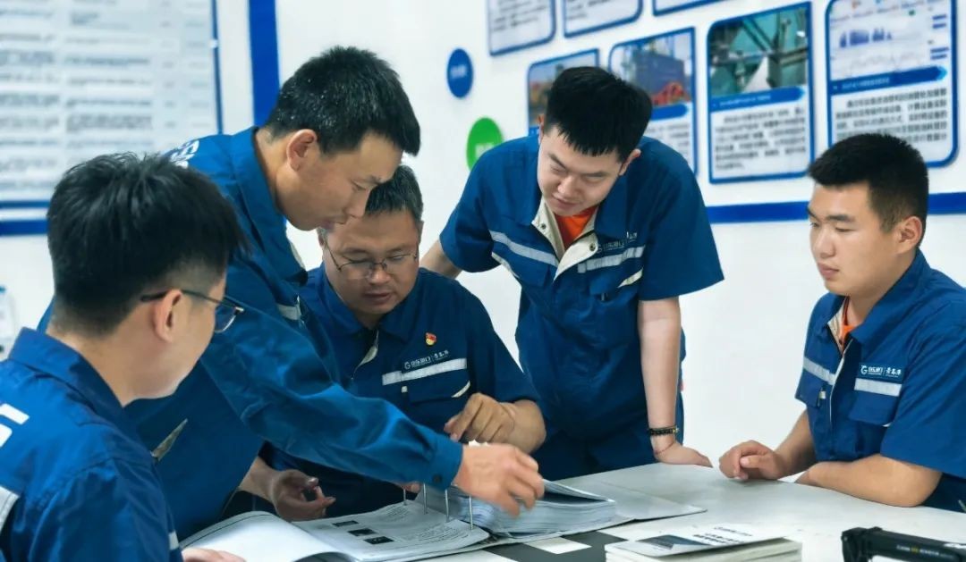 M. Song (&agrave; gauche 3) avec ses coll&egrave;gues discutant de la possibilit&eacute; d'une solution lors d'une r&eacute;union.